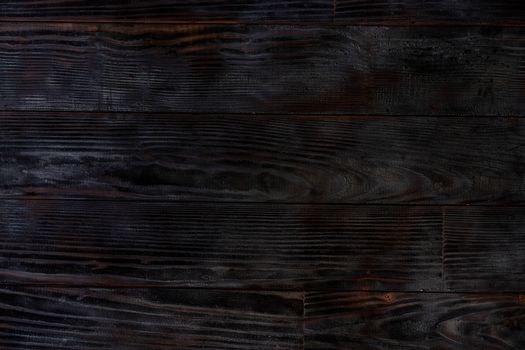 BBQ background. Burnt wooden Board texture. Burned scratched hardwood surface. Smoking wood plank background. Burned wooden grunge texture