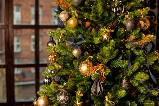 Close-up of a Christmas tree decorated with gold balls and blue bows. Christmas holiday concept. Free space for text