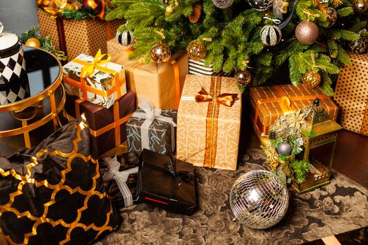 Christmas tree decorated with gold balls. Under the Christmas tree a large number of Christmas gifts. Christmas holiday concept. A huge number of gift boxes under Holiday background