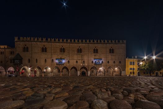 Night view of the Palazzo Ducale from the pavement of Piazza Sordello in Mantua, a night landscape of a historic Italian city