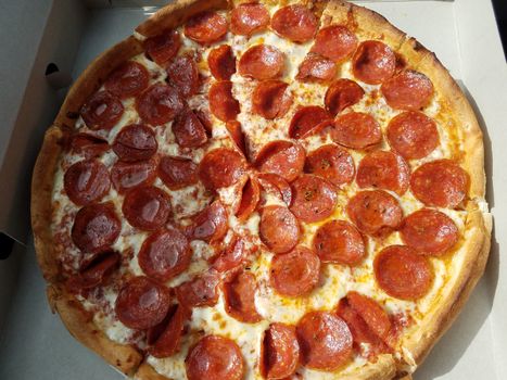 pepperoni meat pizza in cardboard box with grease