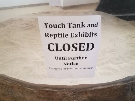 touch tank closed sign with aquarium glass and sand