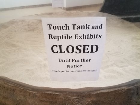 touch tank closed sign with aquarium glass and sand