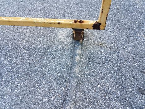 metal gate with groove or damage in asphalt from friction