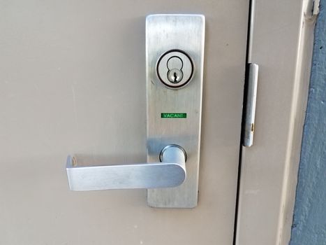 bathroom or restroom door handle with green vacant sign