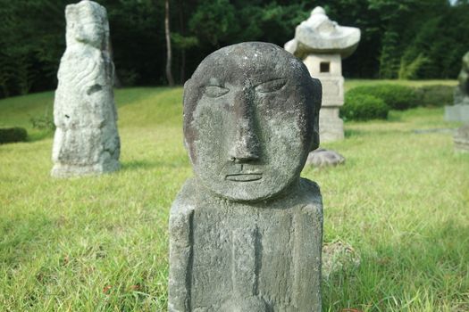 Korean vintage stone statue in the glass field of a public park
