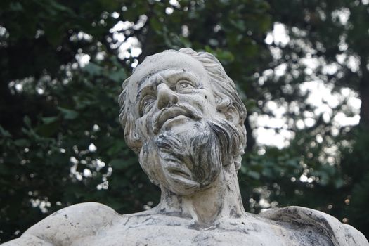 The ancient marble portrait of man with beard placed in a public park