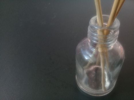 Close-Up Of Incense Sticks In glass Container Against Gray Background. Traditional aroma sticks for fragrance refreshing air