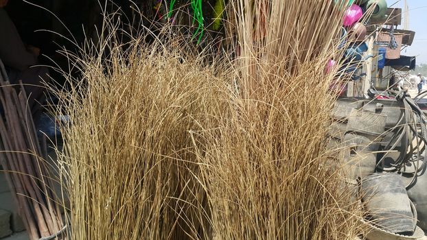 Bunch of brown colored straw broom. Old style broom used for housekeeping in rural area in Asian countries.