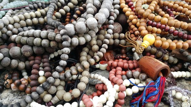 Beautiful wooden prayer beads or rosary placed over fabric background. Religion concept of ramadan or Eid for muslims.