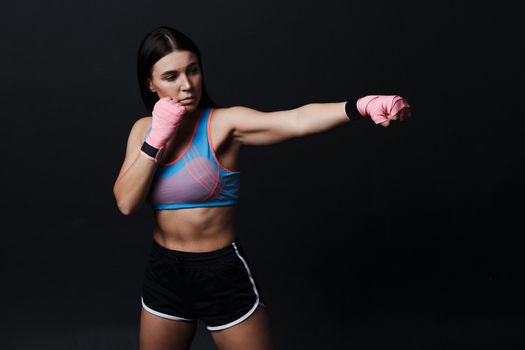 Sportsman muay thai woman boxer posing in training studio