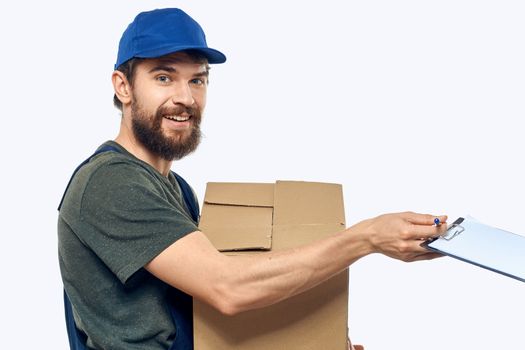 Working male courier with box in hand documents delivery service light background. High quality photo