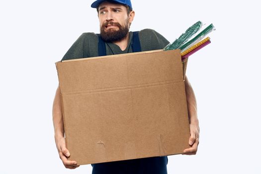 A man in a working uniform with a box in his hands delivery transportation work. High quality photo