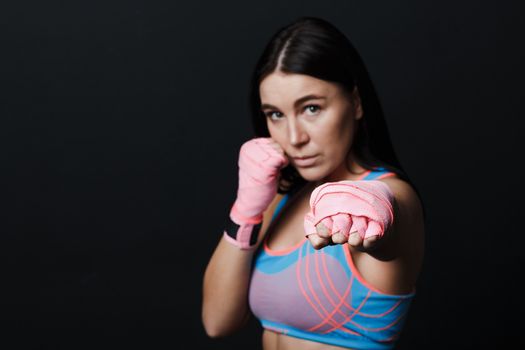 Sportsman muay thai woman boxer posing in training studio