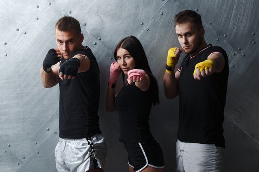 Three boxers man and woman posing before fighting muay thai boxing.