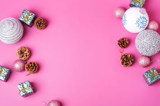 Christmas New Year composition. Gifts, fir tree cones, silver ball decorations on pink background. Winter holidays concept. Flat lay, top view, copy space