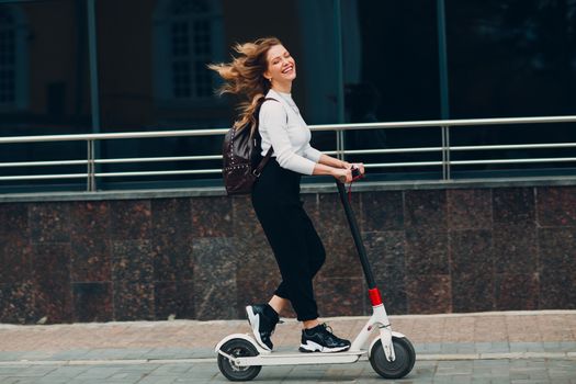 Young woman with electric scooter at the city.