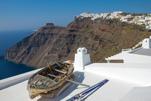 An old boat on a roof and Imerovigli in the back, Santorini island, Greece