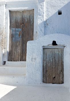 Two rustic wooden doors seen in a greek village