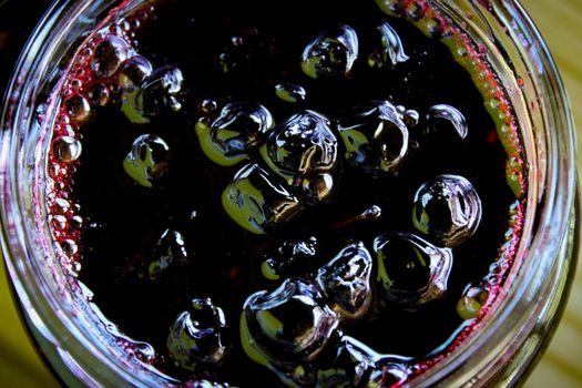 Chokeberry berry jam in a glass jar. Small bubbles around the edges of the jar. Zavidovici, Bosnia and Herzegovina.