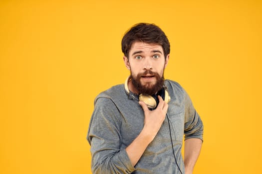 Man in headphones listens to music technology lifestyle fun people yellow background. High quality photo