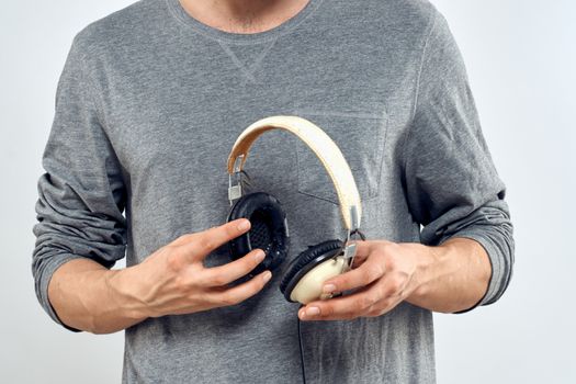 Man holding headphones in the hands of a man lifestyle modern style technology cropped view. High quality photo