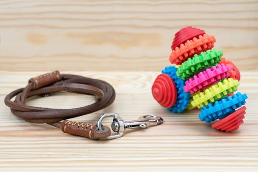 Pet leash and toy for dog on wooden background