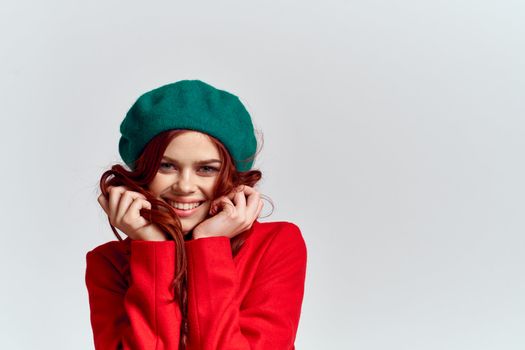 Woman in red coat and in green hat on isolated background cropped model with Copy Space emotions. High quality photo