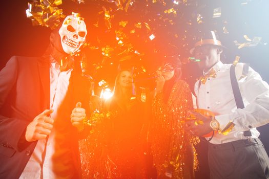 Happy people men and women mixed race dancing together on Halloween party