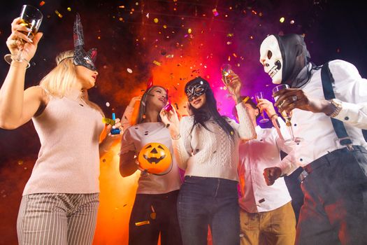 Happy people men and women mixed race dancing together on Halloween party