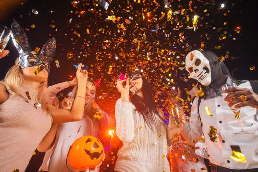 Happy people men and women mixed race dancing together on Halloween party