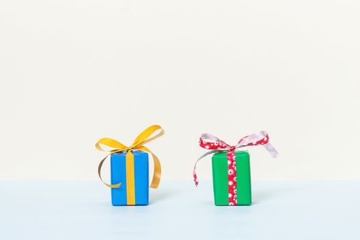 Two colorful gift boxes on a pastel background with space for your text. Front view.