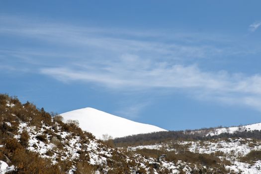 Snowy mountain landscape with a completely snow-covered summit
