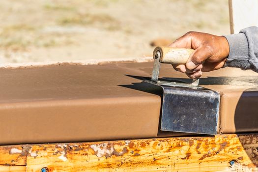 Construction Worker Using Stainless Steel Edger On Wet Cement Forming Coping Around New Pool.