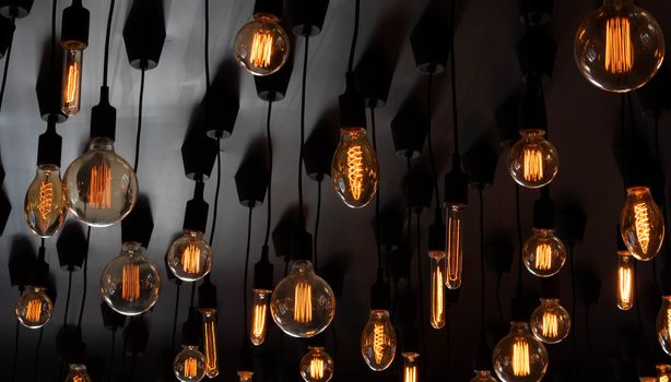 Retro Edison lamp on a black background of the ceiling. Concept idea.