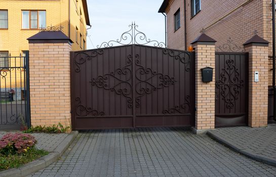 New forged metal double gates for entry of cars into the yard closed.