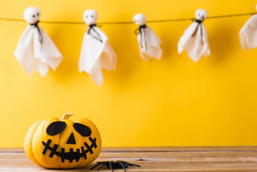 Funny Halloween day decoration party, Baby cute white ghost crafts scary face hanging and halloween pumpkin head jack lantern smile and spider on wooden, studio shot isolated, Happy holiday concept