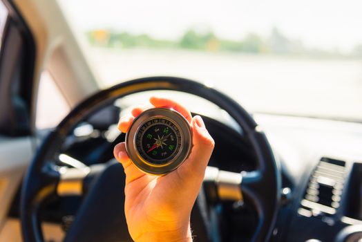 Asian woman inside a car and using compass to navigate while driving the car she find navigation location to go, Transportation and vehicle concept