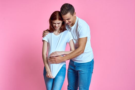 pregnant mom and happy father on pink background Young family waiting for baby. High quality photo