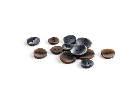 pile, allsorts of brown old gray, beige and brown buttons on a white background. image for sewing and tailor store. space for text