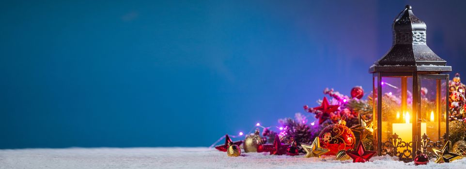 Christmas composition of colorful ornaments balls stars candles and fir tree branches on snow