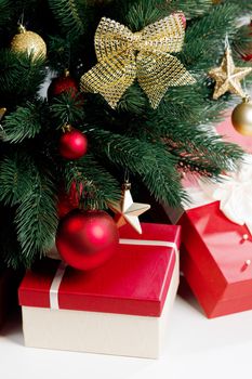 Close up of decorates Christmas tree and gifts on white