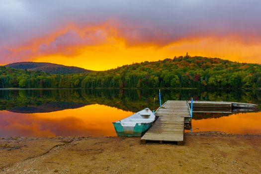 Boat and pier at sunset in Petit Lac Monroe, Mont Tremblant NP, Quebec, Canada