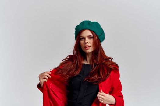 Woman in red coat and in green hat on isolated background cropped model with Copy Space emotions. High quality photo