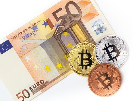 Bitcoins and fifty euro banknote. Financial concept with Bitcoins on fifty euro banknote. Traditional money vs cryptocurrency concept.