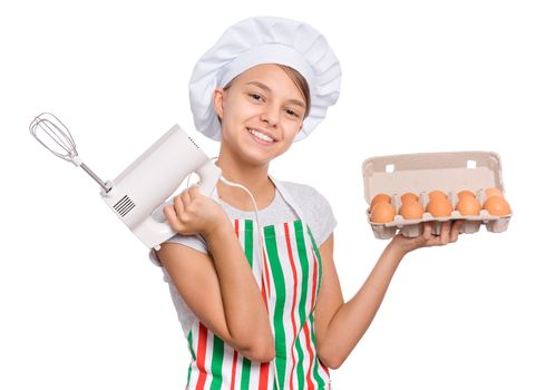 Teen girl in chef hat in apron with egg beater, isolated on white background.