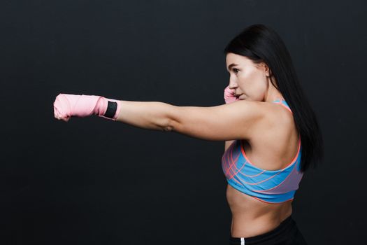 Sportsman muay thai woman boxer posing in training studio