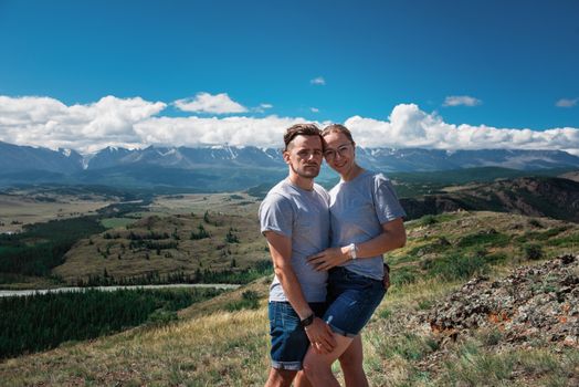 Loving couple together on Altai mountain looking at a view