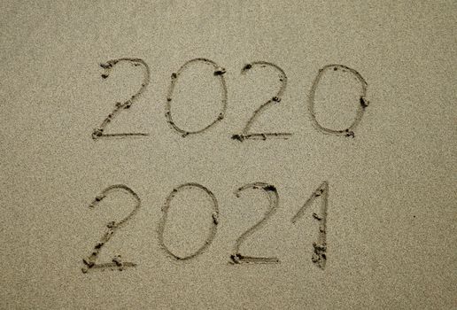 Happy New Year 2021 text on the sea beach. Abstract background photo of coming New Year 2021 and leaving year of 2020.