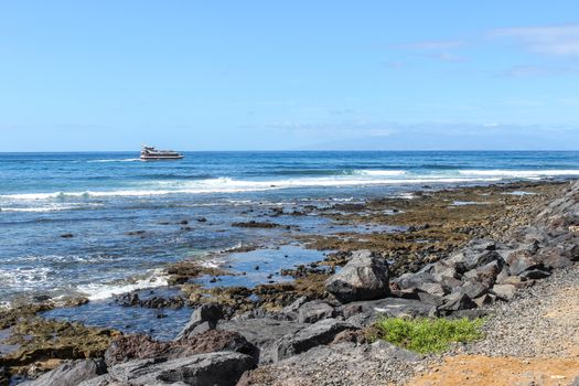 Stony beach at Playa de Las Americas on canary island tenerife with blue water and blue sky